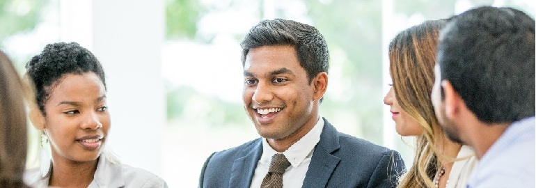 A group of colleagues networking and smiling at each other.