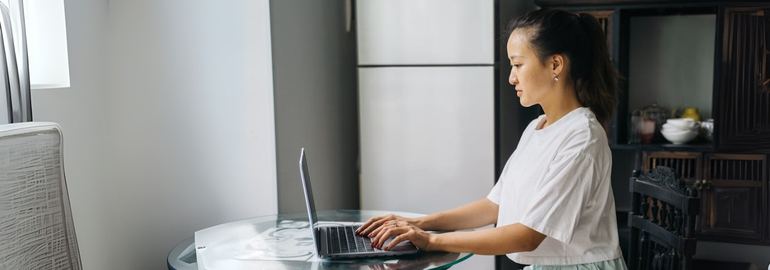 A woman engaged with her laptop, exploring job interview tips for fresh graduates.