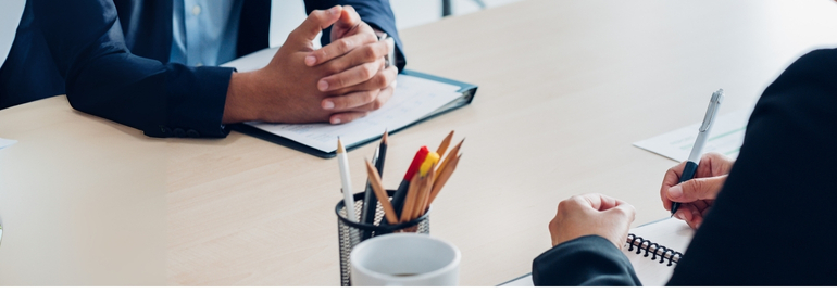 A business meeting with an employer and employee negotiating a counter-offer at a table.
