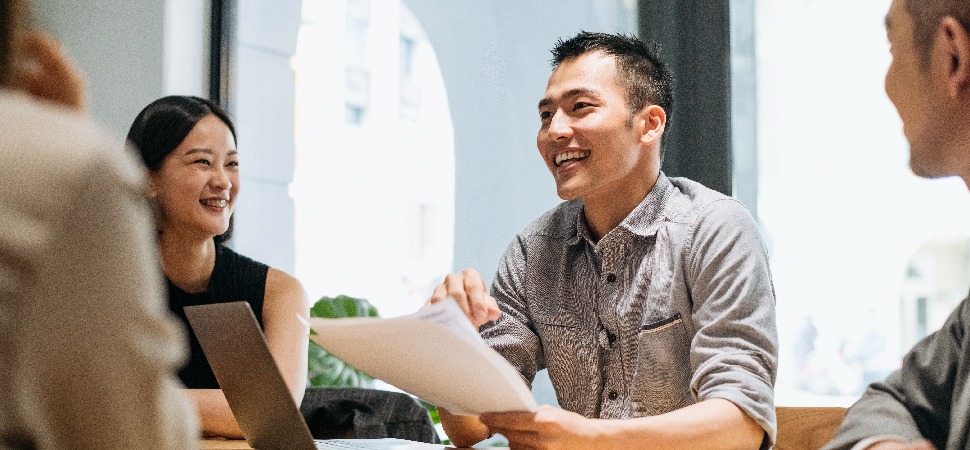 Four professionals in a discussion in an office setting