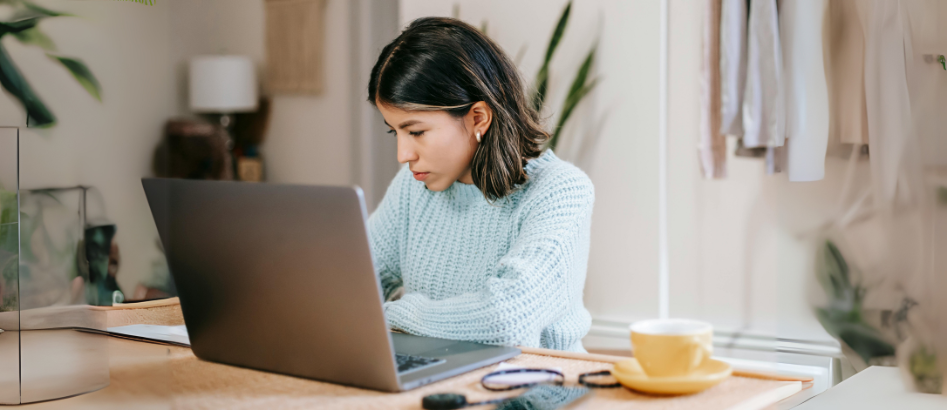A young lady with a laptop researching on what not to say when asked 'Why do you want this job' in a job interview.