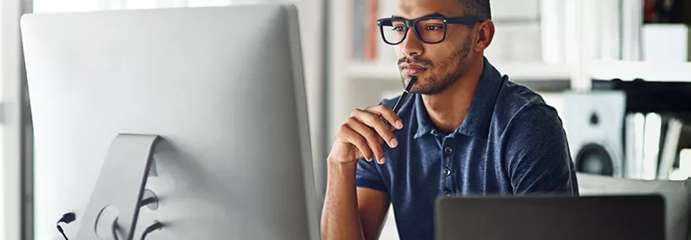 Man wearing glasses working on his computer.