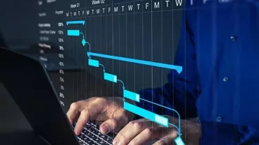 Person using a laptop with a visible project timeline chart on screen.