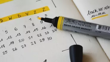 Open planner with a yellow marker on a dated calendar page.