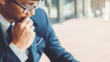 Man in business suit thoughtfully working at a desk.