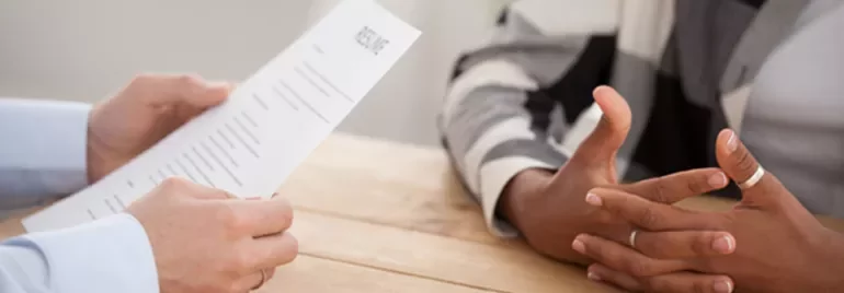 Person holding a resume during a job interview.